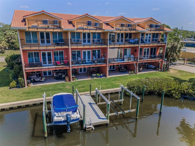 47 W Morgan St, Tarpon Springs, FL 34689 - dock area featuring boat lift, a water view, a patio area, a balcony, and a lawn