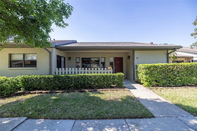 single story home featuring stucco siding and a front lawn