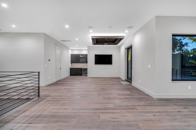 unfurnished living room featuring recessed lighting, baseboards, and light wood-type flooring