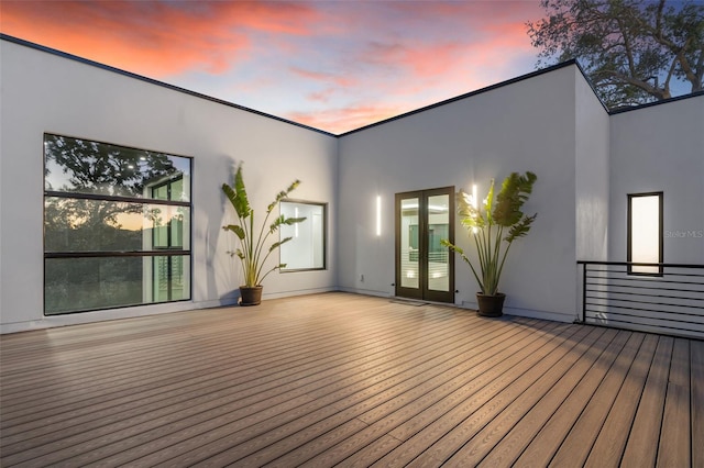 deck at dusk featuring french doors