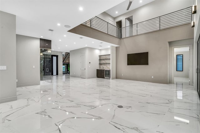 living room featuring recessed lighting, baseboards, marble finish floor, a towering ceiling, and visible vents