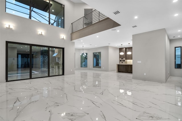 unfurnished living room featuring marble finish floor, recessed lighting, baseboards, and visible vents