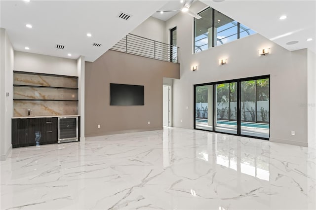 unfurnished living room with marble finish floor, visible vents, wine cooler, and recessed lighting