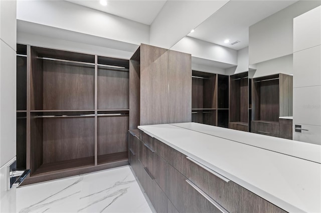 spacious closet featuring marble finish floor