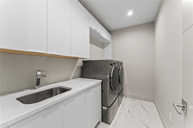 clothes washing area featuring washing machine and clothes dryer, baseboards, marble finish floor, a sink, and cabinet space