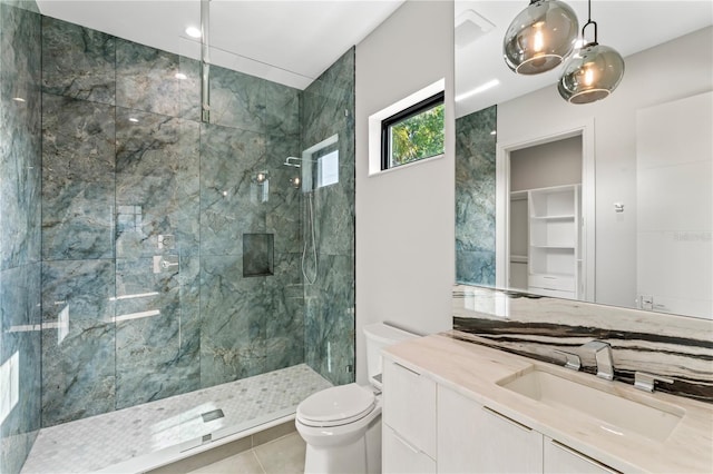 full bath featuring toilet, vanity, tile patterned flooring, and a shower stall