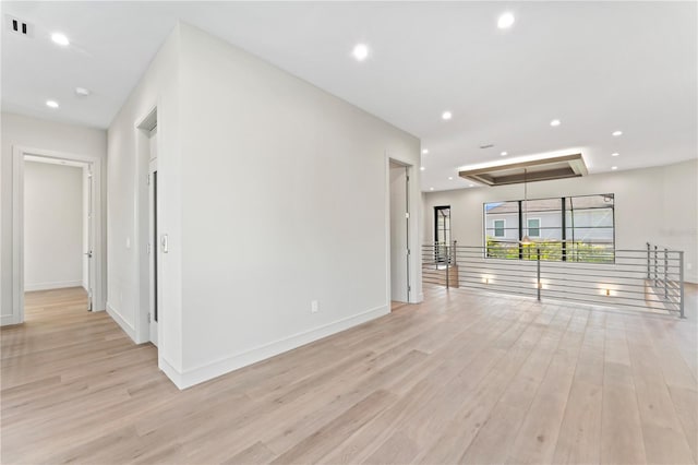 interior space with attic access, light wood-type flooring, baseboards, visible vents, and recessed lighting