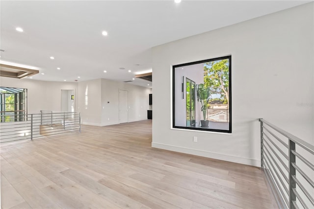 unfurnished room with light wood-style flooring, a wealth of natural light, baseboards, and recessed lighting