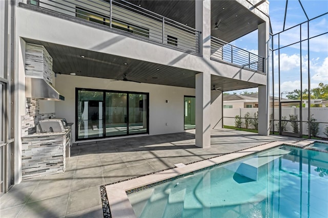 view of pool with ceiling fan, exterior kitchen, a patio area, and a fenced in pool