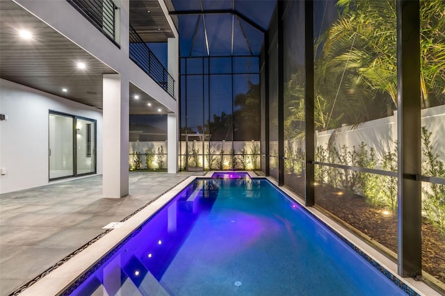 view of pool with glass enclosure, a fenced in pool, a patio, and fence