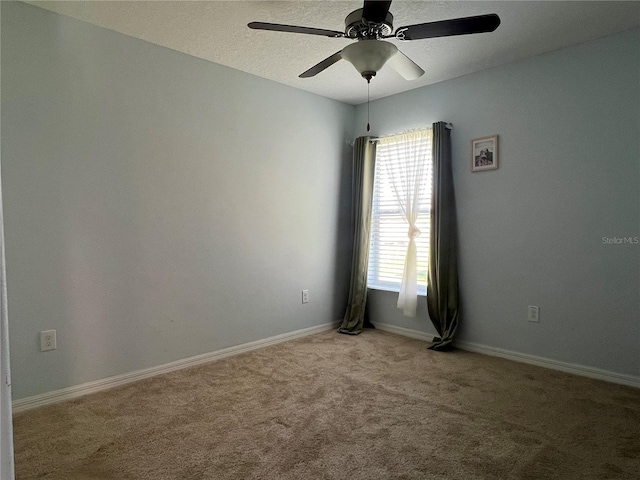 unfurnished room with carpet flooring, a ceiling fan, and baseboards