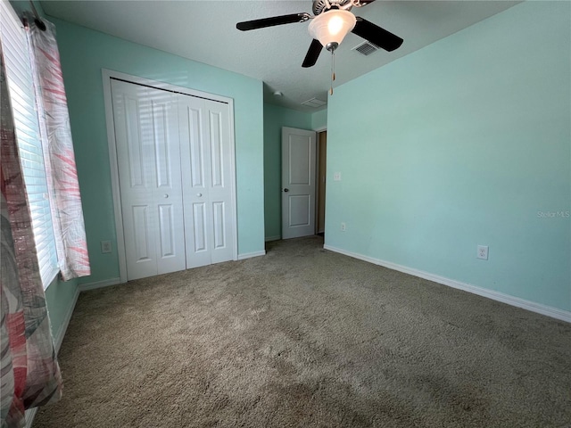 unfurnished bedroom featuring multiple windows, carpet floors, a closet, and baseboards