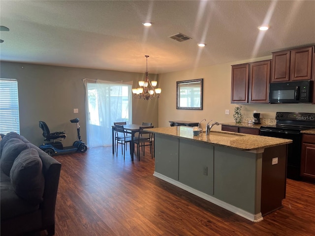 kitchen featuring black appliances, a sink, dark wood-style floors, a chandelier, and an island with sink