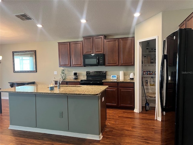 kitchen with black appliances, a sink, dark wood finished floors, a textured ceiling, and light stone counters