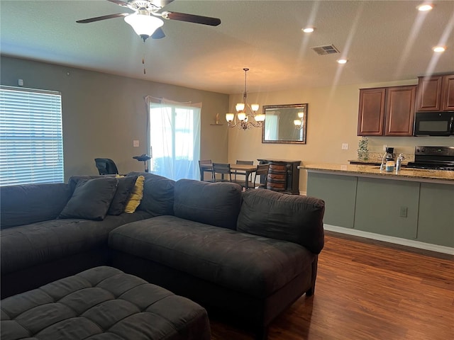 living room featuring dark wood-style flooring, a chandelier, ceiling fan, and recessed lighting