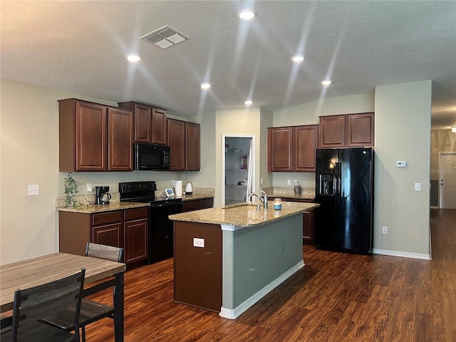 kitchen with black appliances, a sink, a kitchen island with sink, dark wood-style flooring, and dark brown cabinetry