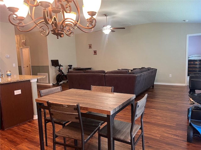 dining room with ceiling fan, dark wood-type flooring, a chandelier, lofted ceiling, and baseboards
