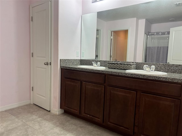 full bathroom with double vanity, curtained shower, baseboards, and tile patterned flooring