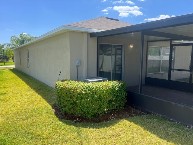 view of home's exterior with stucco siding and a yard