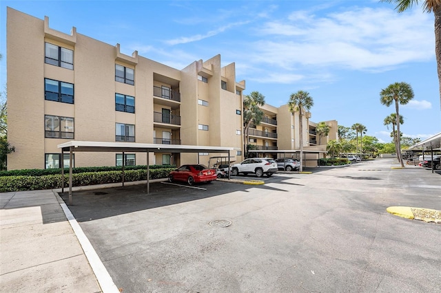 view of property with covered and uncovered parking