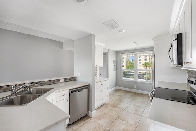 kitchen with white cabinetry, a sink, light countertops, and appliances with stainless steel finishes