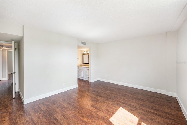 unfurnished room featuring dark wood-type flooring and baseboards