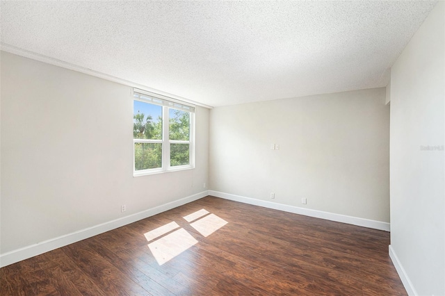 unfurnished room with dark wood-type flooring, baseboards, and a textured ceiling