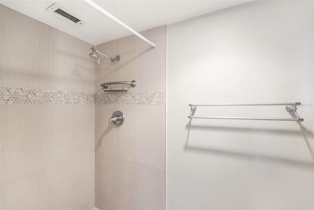 bathroom featuring visible vents and a tile shower