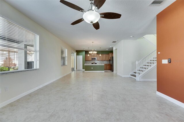 18734 Burndall Ct, Land O Lakes, FL 34638 - unfurnished living room with ceiling fan with notable chandelier, visible vents, a wealth of natural light, and stairs