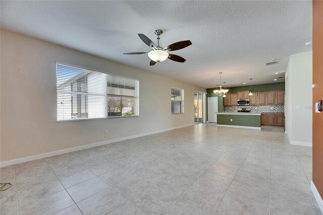 18734 Burndall Ct, Land O Lakes, FL 34638 - unfurnished living room with ceiling fan with notable chandelier, baseboards, a textured ceiling, and light tile patterned floors