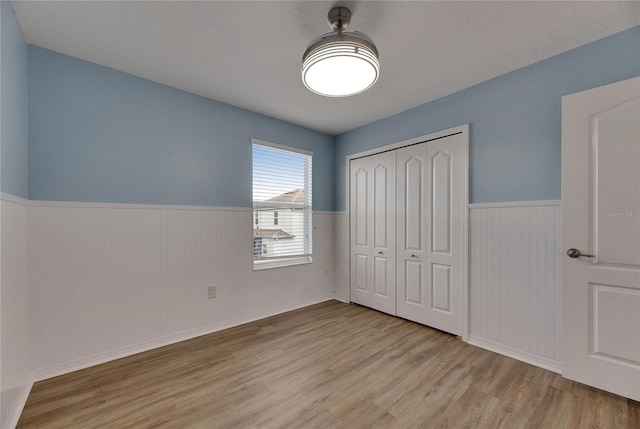 18734 Burndall Ct, Land O Lakes, FL 34638 - unfurnished bedroom featuring wainscoting, wood finished floors, and a closet
