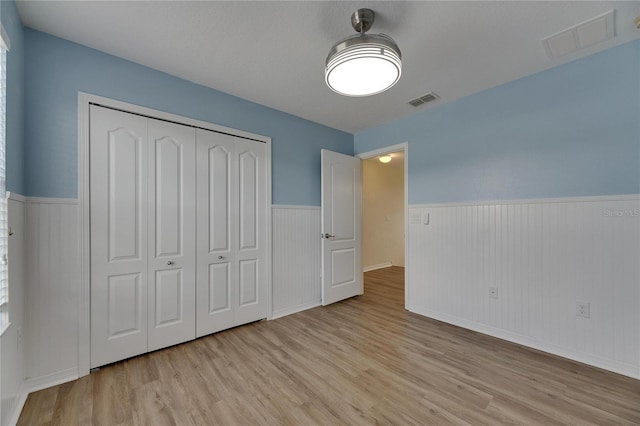 18734 Burndall Ct, Land O Lakes, FL 34638 - unfurnished bedroom featuring wood finished floors, visible vents, and wainscoting