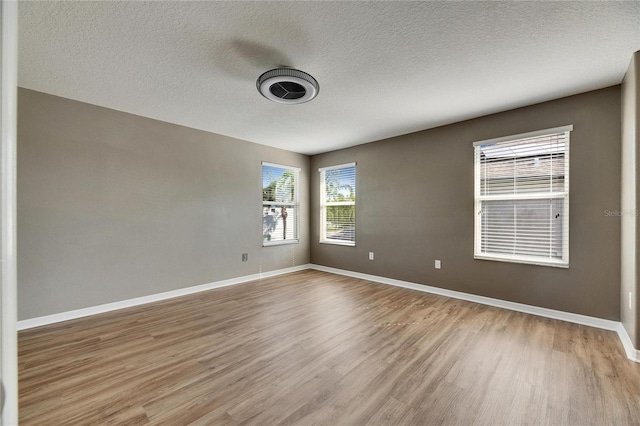 18734 Burndall Ct, Land O Lakes, FL 34638 - empty room featuring baseboards, a textured ceiling, and light wood-type flooring