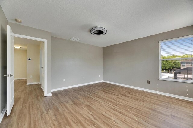 18734 Burndall Ct, Land O Lakes, FL 34638 - unfurnished room with light wood-type flooring, baseboards, visible vents, and a textured ceiling