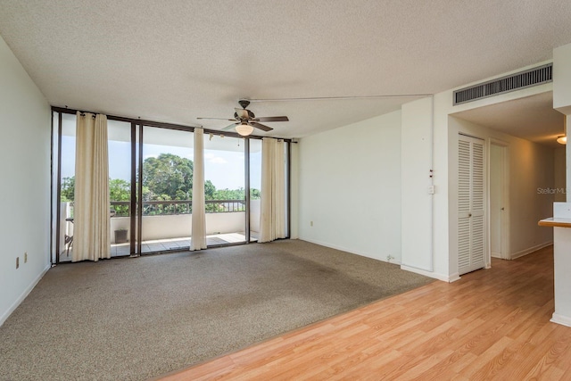 30 Turner St Unit 502, Clearwater, FL 33756 - empty room featuring floor to ceiling windows, a textured ceiling, visible vents, and a ceiling fan
