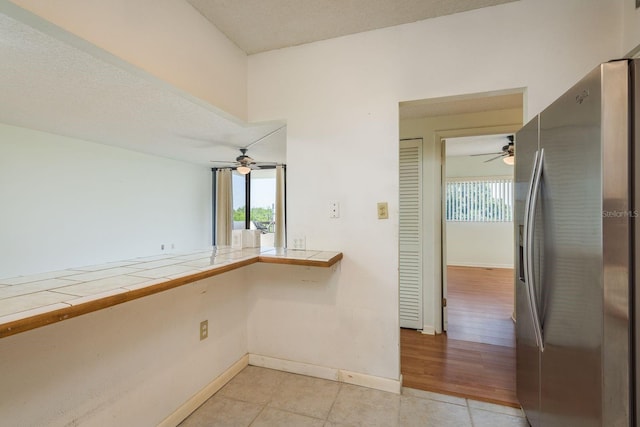 30 Turner St Unit 502, Clearwater, FL 33756 - kitchen featuring tile counters, stainless steel fridge with ice dispenser, light tile patterned flooring, and ceiling fan