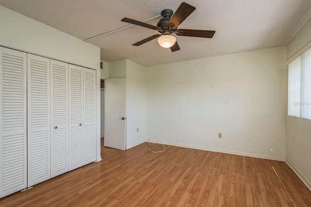 30 Turner St Unit 502, Clearwater, FL 33756 - unfurnished bedroom with a closet, a ceiling fan, light wood finished floors, a textured ceiling, and baseboards