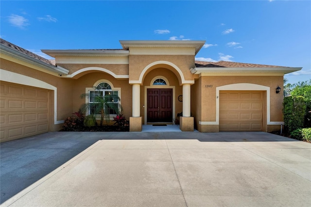 view of front of home with an attached garage, driveway, and stucco siding