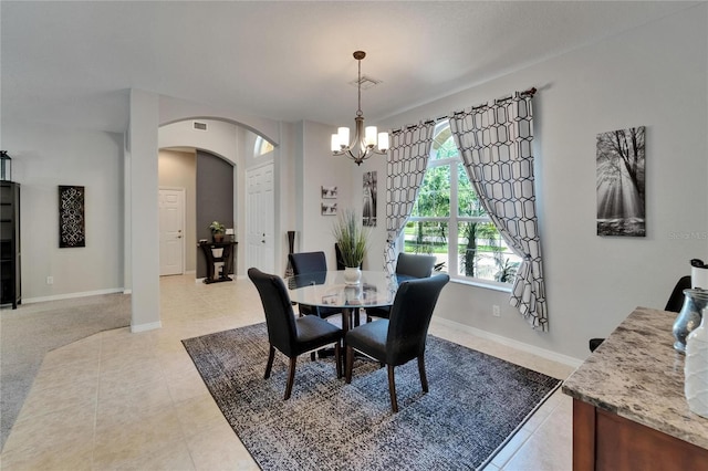 dining area with a chandelier, arched walkways, baseboards, and visible vents
