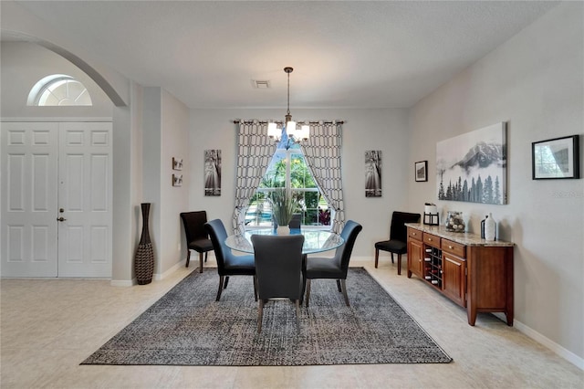dining area featuring visible vents, baseboards, arched walkways, and a chandelier