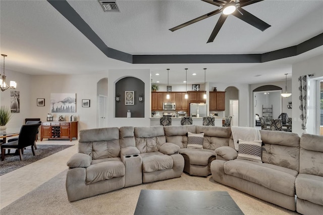 living room with recessed lighting, arched walkways, visible vents, and ceiling fan with notable chandelier