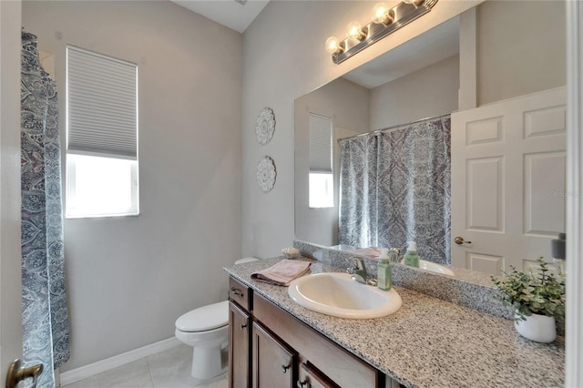 bathroom featuring a shower with shower curtain, vanity, baseboards, tile patterned floors, and toilet