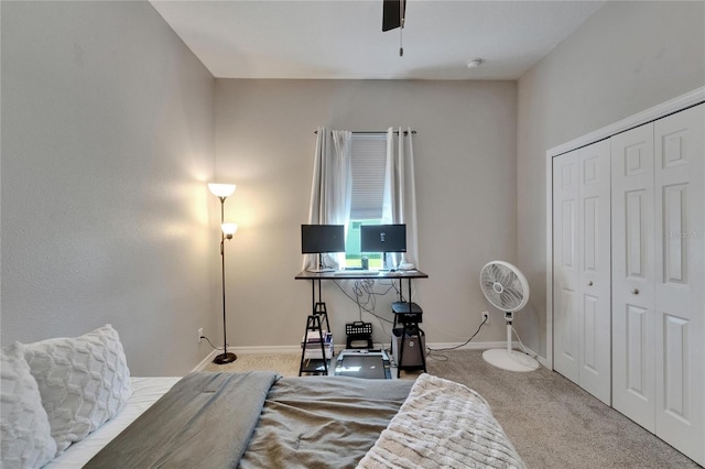 bedroom with a closet, baseboards, a ceiling fan, and carpet