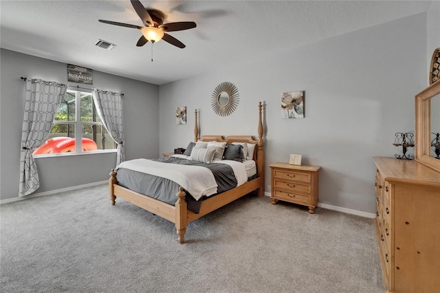 bedroom with baseboards, a textured ceiling, visible vents, ceiling fan, and light colored carpet