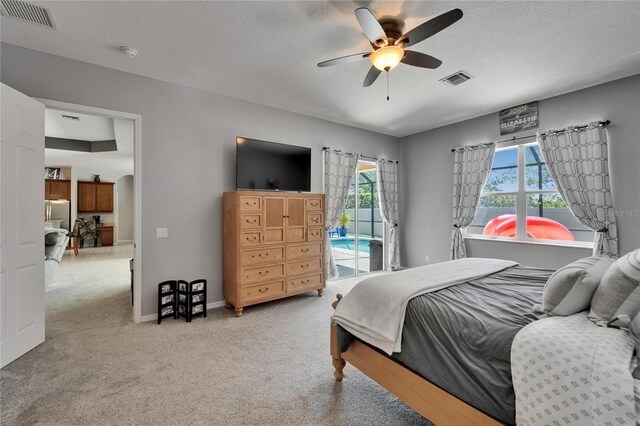 bedroom featuring access to outside, a textured ceiling, visible vents, and carpet floors