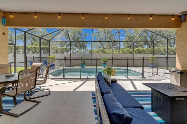 view of swimming pool featuring an outdoor living space, glass enclosure, a patio area, fence, and a fenced in pool