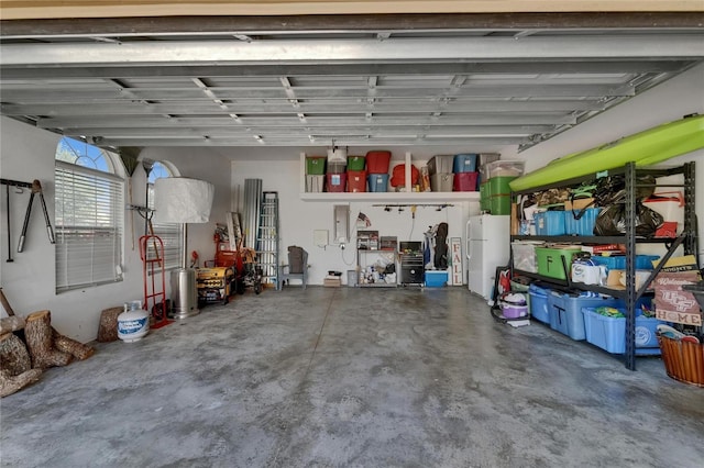 garage with freestanding refrigerator and electric panel