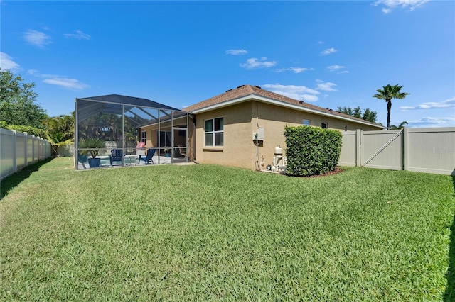 rear view of property featuring a yard, a fenced backyard, stucco siding, a patio area, and a lanai
