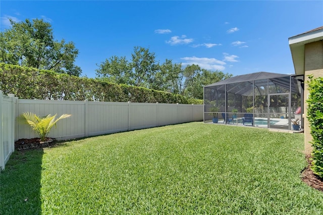 view of yard with a fenced in pool, a fenced backyard, and a lanai