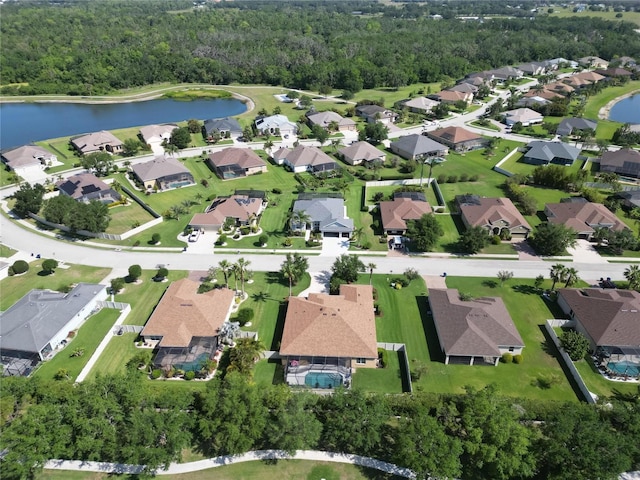 bird's eye view featuring a water view, a residential view, and a wooded view